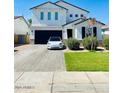 Charming two-story home with a well-kept lawn and a Tesla in the driveway at 512 E Bamboo Ln, San Tan Valley, AZ 85140