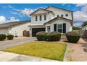 Beautiful home with manicured bushes, a dark garage door, and a neatly kept lawn at 512 E Bamboo Ln, San Tan Valley, AZ 85140