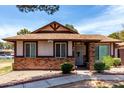 Charming single-story home with a brick facade, a well-manicured lawn, and a cozy front porch at 5135 E Evergreen St # 1166, Mesa, AZ 85205