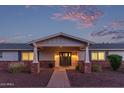 A charming home entrance with a covered porch and brick accents under a picturesque sky at 6231 E Desert Cove Ave, Scottsdale, AZ 85254
