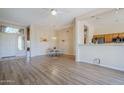 Bright living area with wood floors that opens into the kitchen and dining area at 7094 E Palo Brea Dr, Gold Canyon, AZ 85118