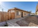 Exterior view of tan apartment building with security door and a wood fence on the side at 7101 N 36Th Ave # 102, Phoenix, AZ 85051