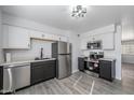 Modern kitchen with stainless steel appliances, gray cabinets, white walls, and wood look floors at 7101 N 36Th Ave # 102, Phoenix, AZ 85051