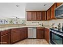 Well-lit kitchen features stainless steel appliances, tile floors, and beautiful wood cabinets at 973 E Kelsi Ave, San Tan Valley, AZ 85140