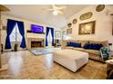 Bright living room with a fireplace, TV, tile floors, and comfortable seating at 11022 N 60Th Dr, Glendale, AZ 85304