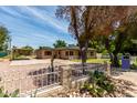 Wide view of the house, showing a covered parking area behind the home and desert landscaping at 1134 W 2Nd St, Mesa, AZ 85201