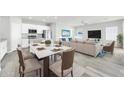Beautiful open-concept living space with modern dining area and sleek white kitchen at 14178 S Diablo Rd, Arizona City, AZ 85123