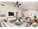 Bright living room featuring modern furniture, a ceiling fan, and wood floors for a stylish and comfortable space at 1608 S 82Nd Dr, Phoenix, AZ 85043