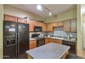 Well-lit kitchen with granite countertops, stainless appliances, decorative tile backsplash, and wood cabinets at 1718 W Colter St # 126, Phoenix, AZ 85015