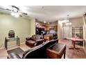 Open-concept living room featuring wood floors, ceiling fan, stylish furniture, and connected kitchen at 1718 W Colter St # 126, Phoenix, AZ 85015