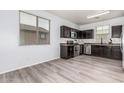 Well-lit kitchen with stainless steel appliances, wooden cabinets and laminate flooring at 1733 N 77Th Dr, Phoenix, AZ 85035