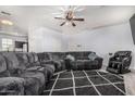 Spacious living room featuring a large grey sectional, wood flooring, and ceiling fan at 1733 N 77Th Dr, Phoenix, AZ 85035