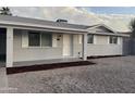 Charming single story home featuring a light grey brick, complimented by fresh mulch and rock landscaping at 1813 E Boise St, Mesa, AZ 85203