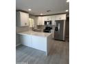 Bright kitchen featuring white cabinetry, stainless steel appliances, and a peninsula counter at 1813 E Boise St, Mesa, AZ 85203