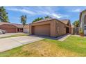 Exterior view of the home featuring a large two-car garage and a well-manicured lawn at 1836 N Stapley Dr # 191, Mesa, AZ 85203