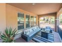 Relaxing covered back porch with comfortable seating, a fire pit, and views of the lush backyard at 20557 W Lost Creek Dr, Buckeye, AZ 85396
