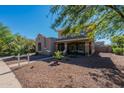 Inviting two-story house featuring a cozy front porch, desert landscaping, and a well-maintained exterior at 20557 W Lost Creek Dr, Buckeye, AZ 85396