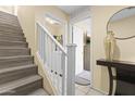 Entryway with hardwood stairs, and white banister leading to the second floor; laundry room is off to the right at 2111 N 77Th Gln, Phoenix, AZ 85035