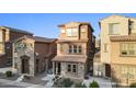 Inviting two-story home with stone accents, a tiled roof, and a cozy front porch at 2111 N 77Th Gln, Phoenix, AZ 85035