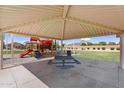 Playground with picnic table and cover in a well maintained and landscaped community park at 2738 E Silversmith Trl, San Tan Valley, AZ 85143