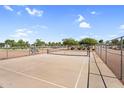 Fenced tennis court with blue benches, net, and a view of community landscaping at 2738 E Silversmith Trl, San Tan Valley, AZ 85143