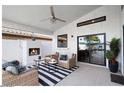 Charming covered patio featuring a fireplace, comfortable seating, and access to the pool area at 3224 E Desert Cove Ave, Phoenix, AZ 85028