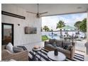 Inviting covered patio with comfortable seating, ceiling fan, and a view of the pool and palm trees at 3224 E Desert Cove Ave, Phoenix, AZ 85028