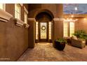 Inviting front entrance of home featuring a decorative iron door, stylish sidelights, and elegant architectural details at 3460 E Lynx Pl, Chandler, AZ 85249