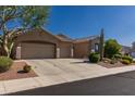 Charming single-Gathering home featuring desert landscaping, three-car garage, and a neutral color palette at 4241 E Andre Ave, Gilbert, AZ 85298