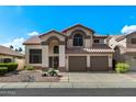 Beautiful two-story home featuring a well-manicured front yard, tiled roof, and attached two-car garage, under a blue sky at 4446 E Woodridge Dr, Phoenix, AZ 85032