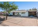 Charming single-story home with blue exterior, decorative rock yard, large carport and a long driveway at 8724 N 28Th Ave, Phoenix, AZ 85051