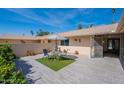Inviting courtyard featuring a modern table and chairs on artificial turf and stylish tile flooring at 10644 W Campana Dr, Sun City, AZ 85351