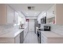 Modern kitchen featuring white cabinets, sleek countertops, stainless steel appliances, and a stylish tile backsplash at 10644 W Campana Dr, Sun City, AZ 85351