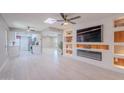 Bright, open-concept living room boasts sleek floors, custom built-ins, and a modern fireplace with updated fixtures at 10644 W Campana Dr, Sun City, AZ 85351