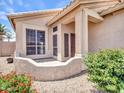 Inviting front entrance with tiled porch and lush landscaping at 11547 W King Snake Ct, Surprise, AZ 85378
