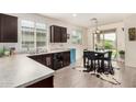 Eat-in kitchen features stainless steel appliances, dark wood cabinets, light countertops and sliding glass doors to the backyard at 17573 W Via De Luna Dr, Surprise, AZ 85387
