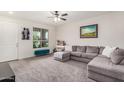 Living room featuring a large sectional couch, light gray carpet, and a window letting in natural light at 17573 W Via De Luna Dr, Surprise, AZ 85387