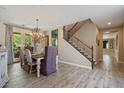 Elegant dining room featuring hardwood floors, a modern chandelier, table and chairs, and staircase at 20638 W Main St, Buckeye, AZ 85396