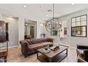 Cozy living room with leather sofa, area rug, and stylish light fixture creating a comfortable ambiance at 20638 W Main St, Buckeye, AZ 85396