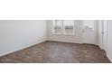 Bright bedroom with new hardwood floors, natural light from two windows and a white door at 2067 W Sheridan Ave, Apache Junction, AZ 85120