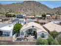 Aerial view of a desert home featuring a backyard patio, mountain views, and low maintenance landscaping at 21 W Cochise Dr, Phoenix, AZ 85021