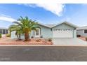 Attractive home exterior with blue vinyl siding, desert landscaping and a two-car garage at 215 N Power Rd # 33, Mesa, AZ 85205