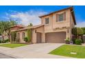 Elegant house with a three car garage, manicured lawn, and beautiful stone accents around the courtyard entry at 2308 E Aster Dr, Chandler, AZ 85286