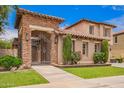 Beautiful front yard view showcasing a stone accented entry and an iron gate leading to a private courtyard at 2308 E Aster Dr, Chandler, AZ 85286