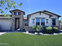 Charming home boasts a well-manicured lawn and stylish stone accents, creating an inviting curb appeal at 25602 S 229Th Pl, Queen Creek, AZ 85142