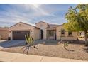 Charming single-story home with a two-car garage, desert landscaping, and a tile roof in a sunny setting at 2599 E San Mateo Dr, Casa Grande, AZ 85194