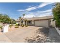 Inviting single-story home with a two-car garage and desert landscaping at 3307 E Roveen Ave, Phoenix, AZ 85032