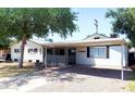 Charming single-story home with a covered carport, white exterior, and mature trees at 3330 E Cypress St, Phoenix, AZ 85008