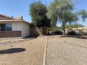 Gravel backyard with mature trees and partial fence at 3341 E Cochise Rd, Phoenix, AZ 85028