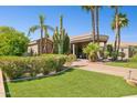 Expansive estate featuring a circular driveway, desert landscaping, and a grand entrance portico providing shade at 3731 E Halifax Cir, Mesa, AZ 85205